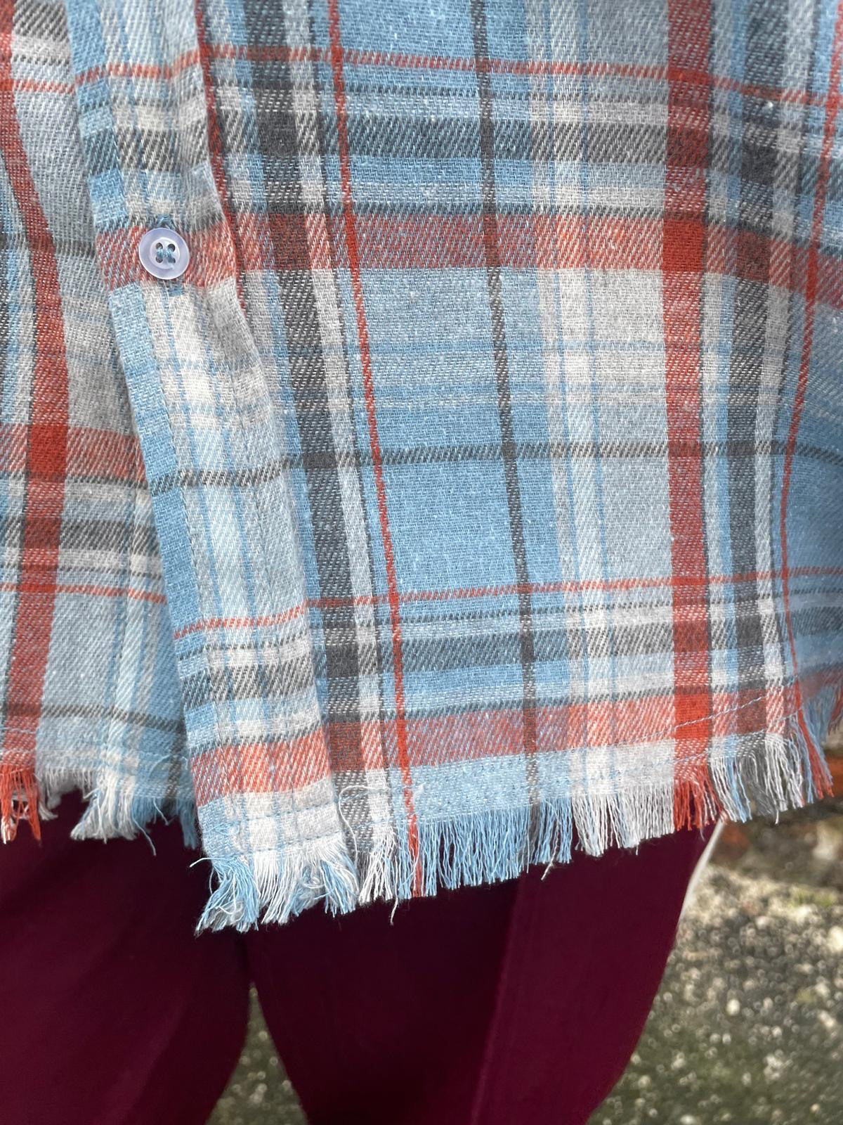 Close-up of a plaid fabric with red, blue, and gray colors.