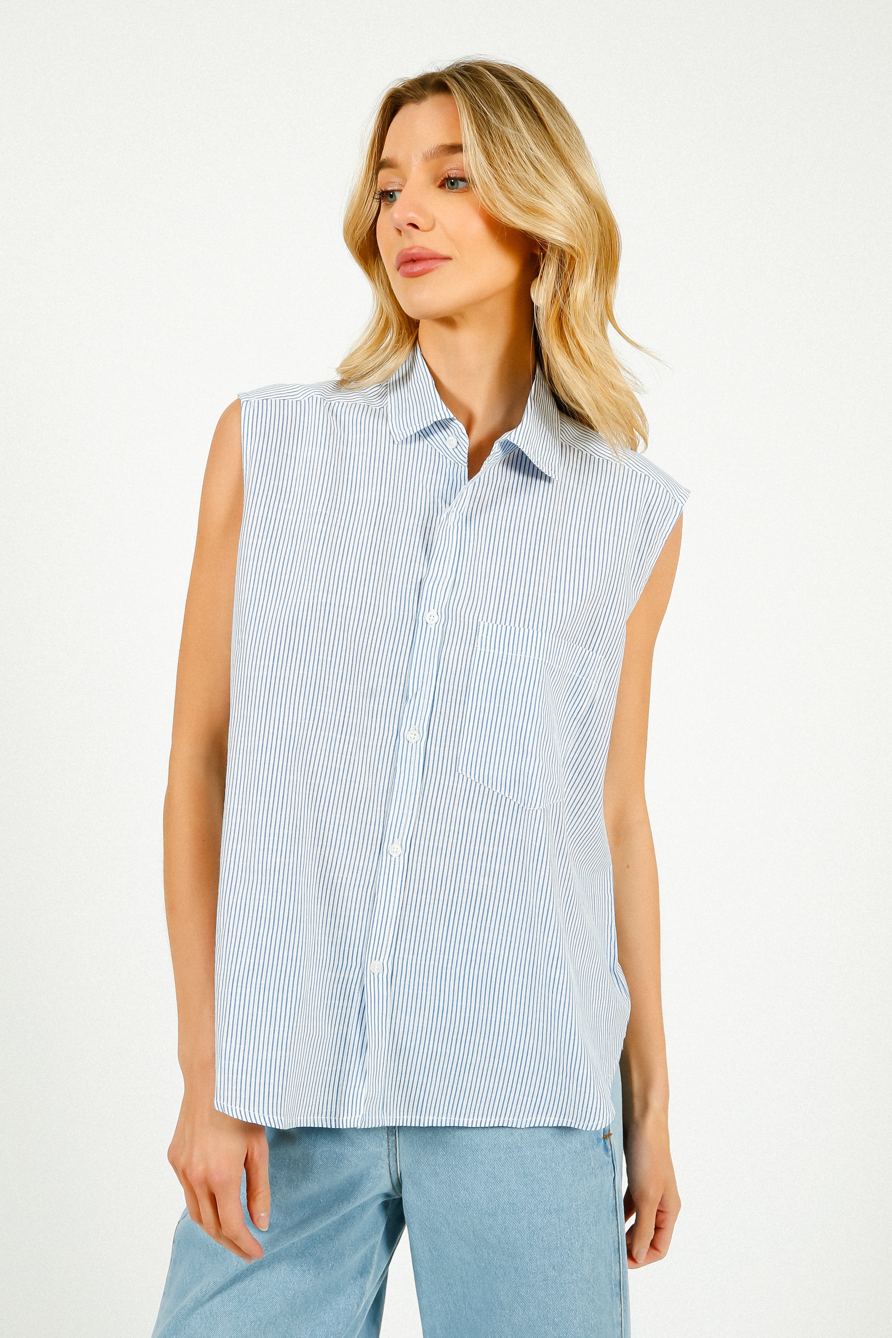 A woman modeling a sleeveless blue and white striped shirt with a classic collar.