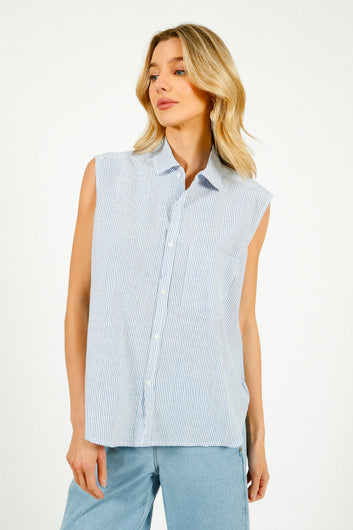 A woman modeling a sleeveless blue and white striped shirt with a classic collar.