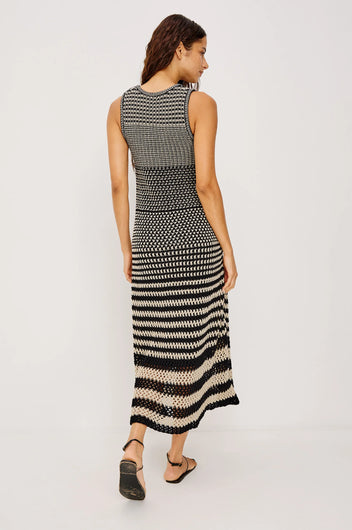 Woman wearing a black and white patterned dress on a light gray background