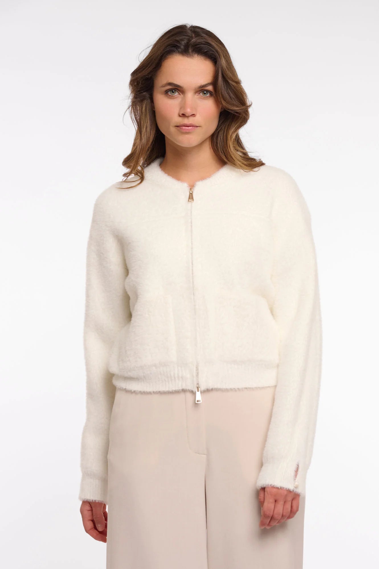 Rino & Pelle Bento Cardi in Snow White Woman wearing a cream-colored zip-up sweater against a white background