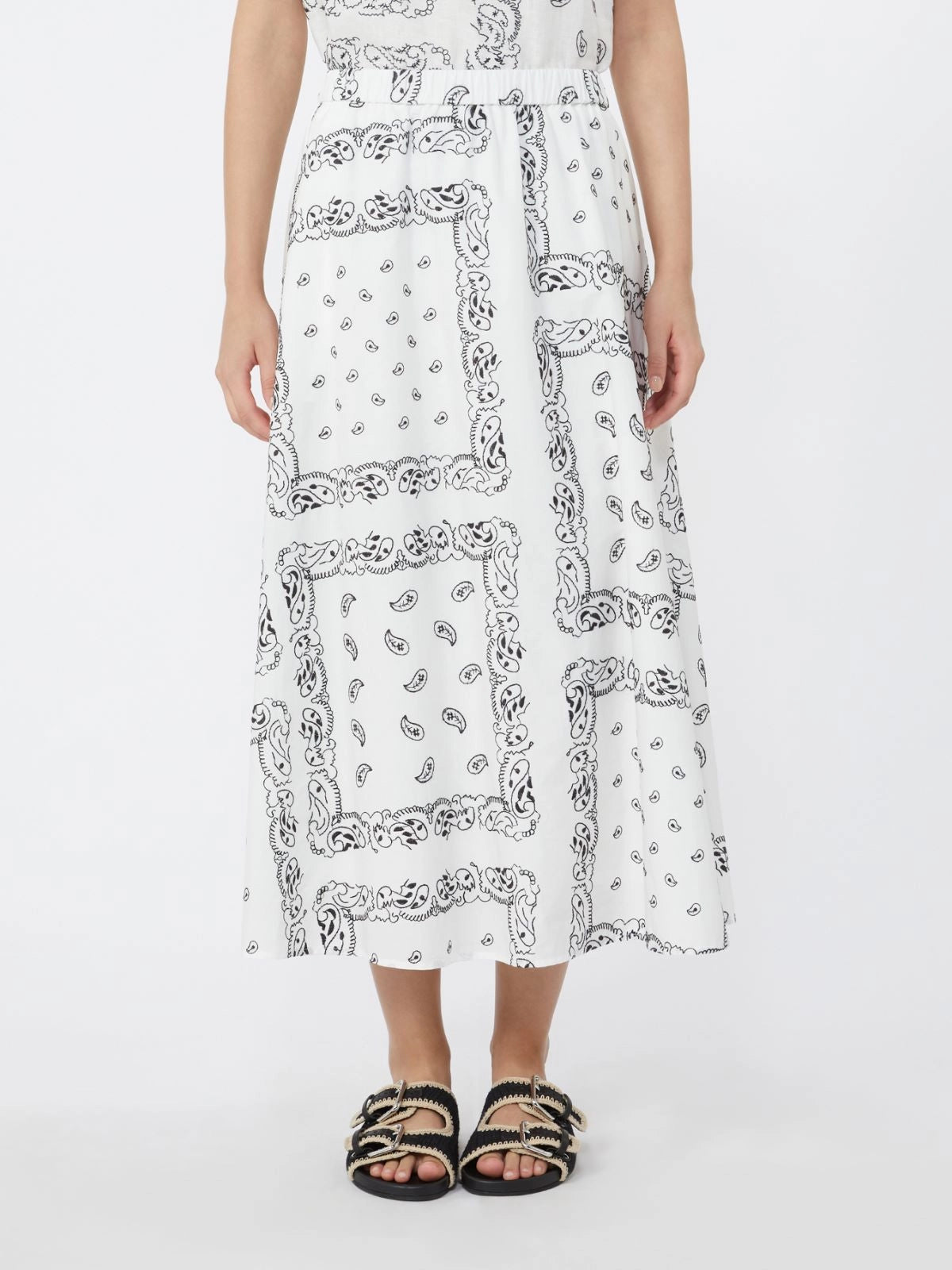 Person wearing a white dress with black pattern on a white background