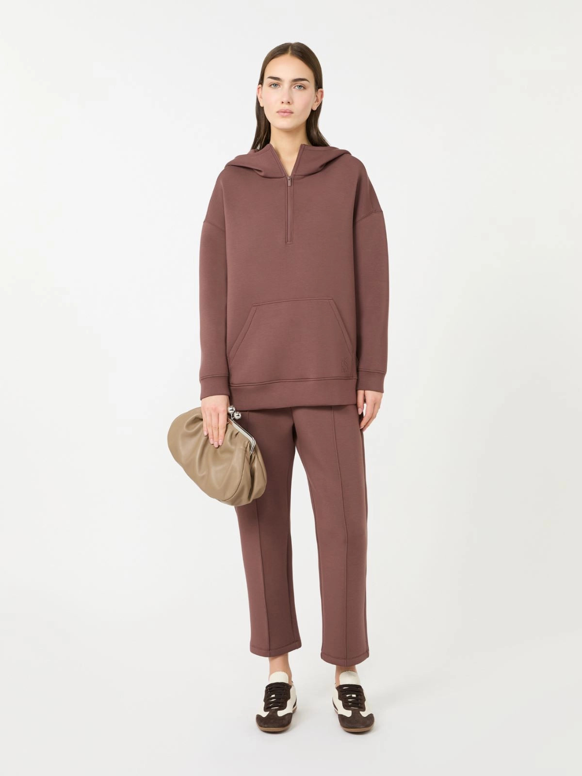 Weekend Maxmara Utopia Trousers in Brown Woman wearing a brown hoodie and pants holding a beige bag on a white background